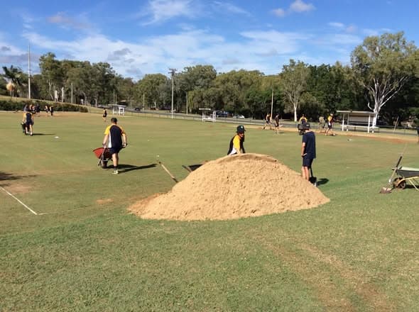Gladstone High School volunteers help top dress courts